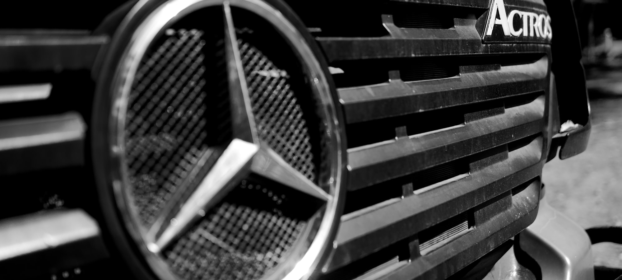 Schwarzweiß-Nahaufnahme des Kühlergrills einer Mercedes-Benz-Actros-Zugmaschine